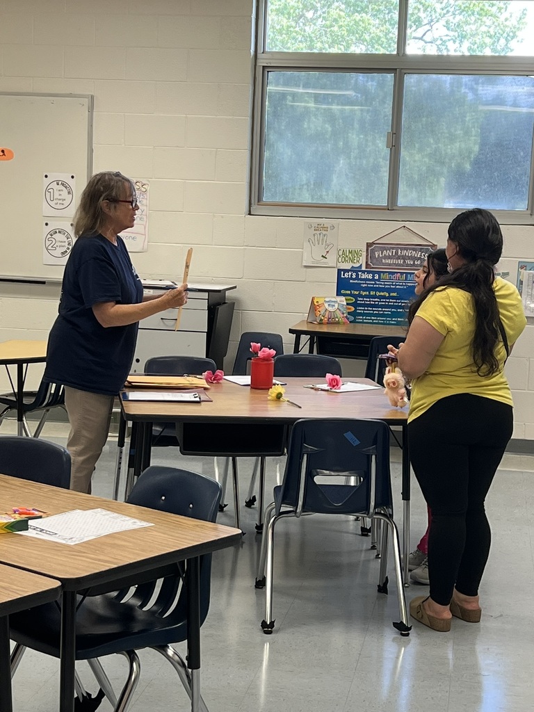 Teacher talking with a parent inside a classroom during open house.