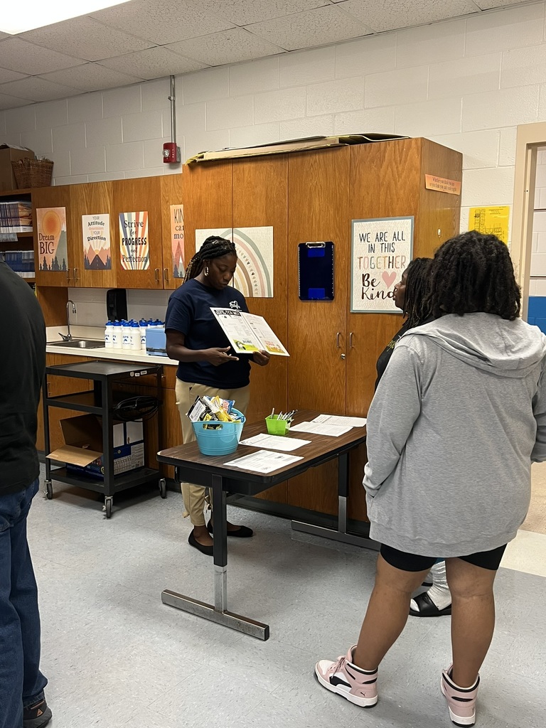 Teacher talking with a parent inside a classroom during open house.