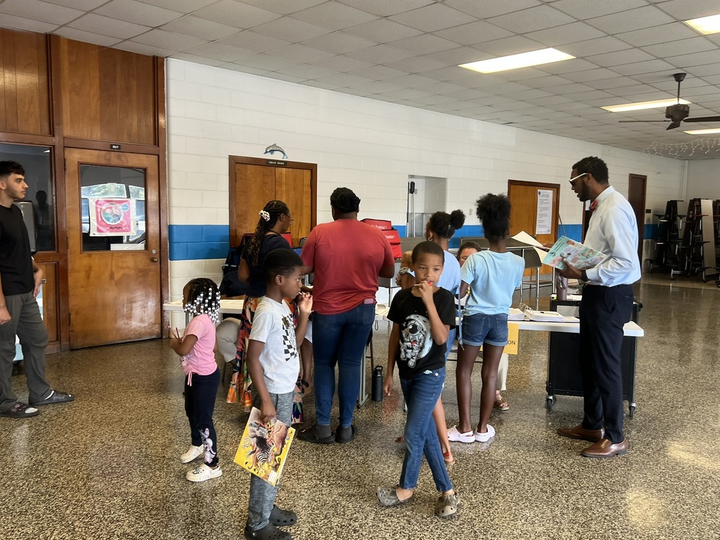 Teacher sharing information with parents at a classroom table.