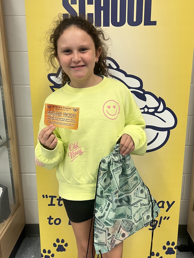 Golden ticket winner at middle school- girl wearing a yellow shirt and black shorts holding a golden ticket and prize