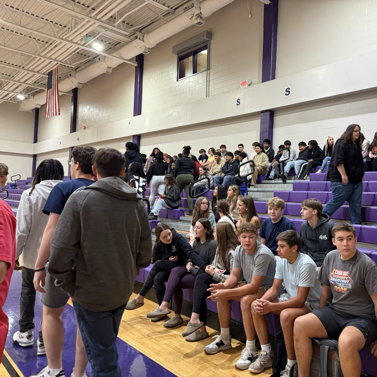 students entering the gym and sitting in the bleachers 