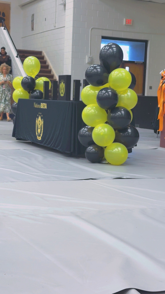 A National Beta Club table decorated with black and yellow balloons set up for the Induction ceremony.