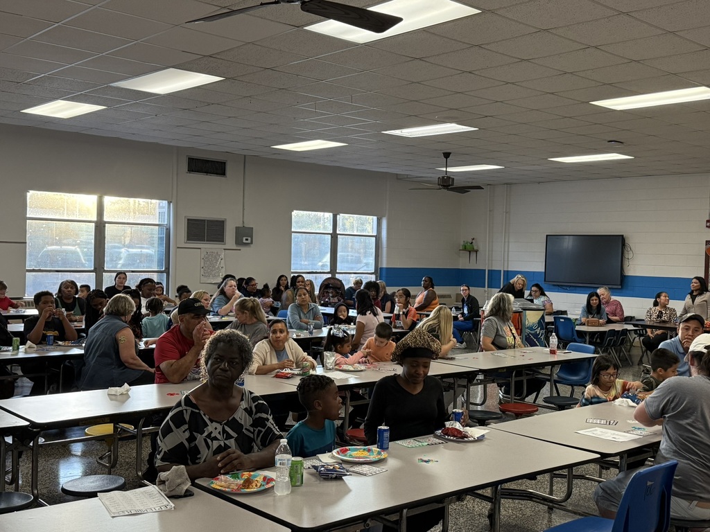 Parents, students, and staff gathered in the cafeteria playing Bingo together.