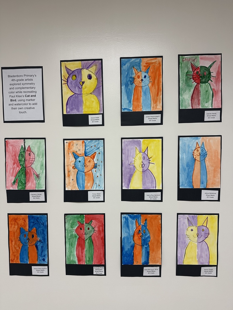 A wall display of 4th-grade student art from Bladenboro Primary, recreating Paul Klee’s Cat and Bird. Each cat drawing uses symmetry, bold complementary colors, and watercolor backgrounds, with each student adding unique creative touches.