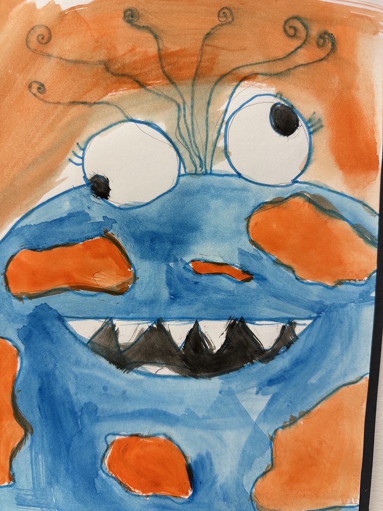 A colorful painting of a blue and orange monster with big eyes, sharp black teeth, and curly antennae-like hair at the top.