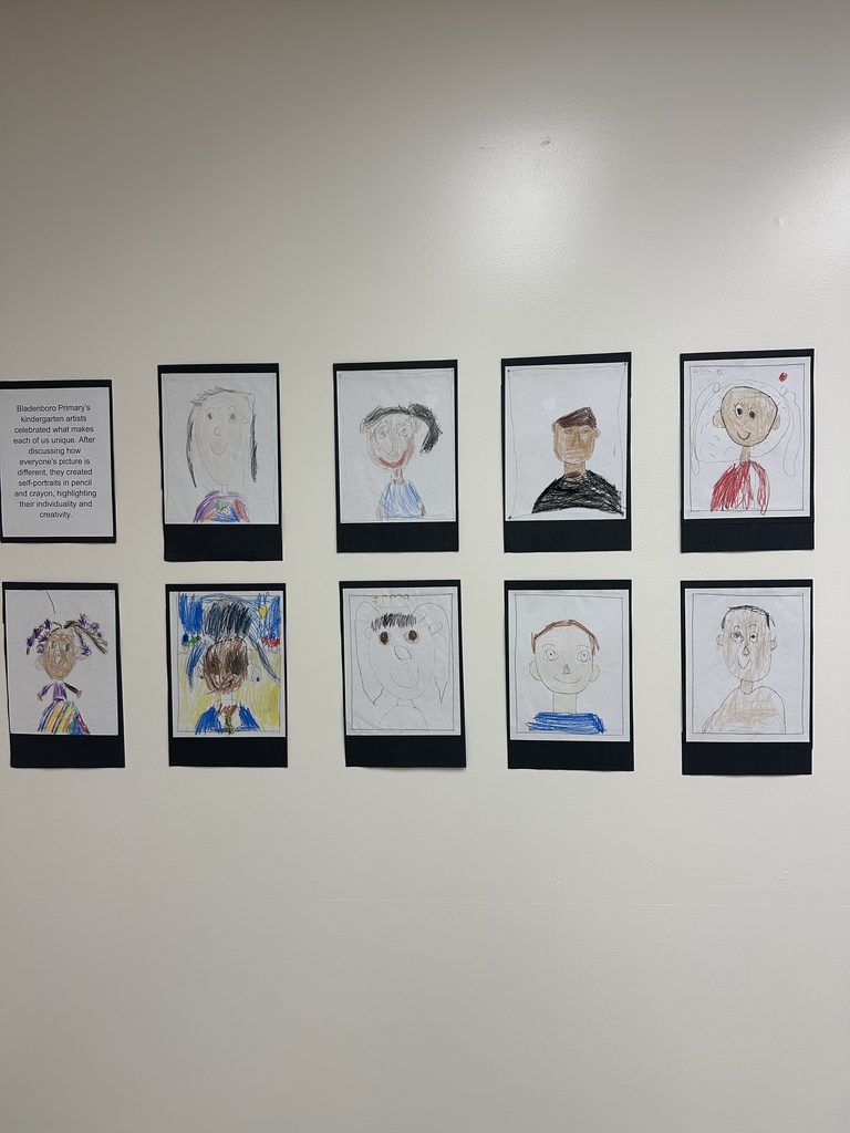 A wall display of kindergarten self-portraits from Bladenboro Primary. Drawn with pencil and crayon, the portraits highlight individuality, with different hairstyles, skin tones, and colorful clothing to celebrate what makes each student unique.