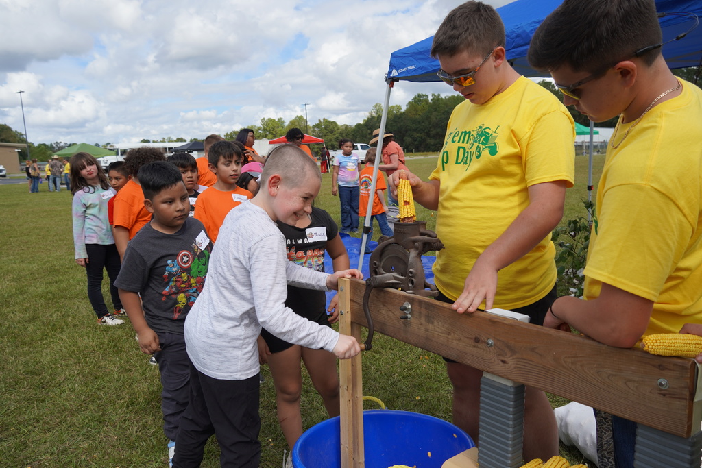 Students participate in hands-on agriculture activities during Ag ‘Em Up Day, learning about farm equipment, animals, and crop production.
