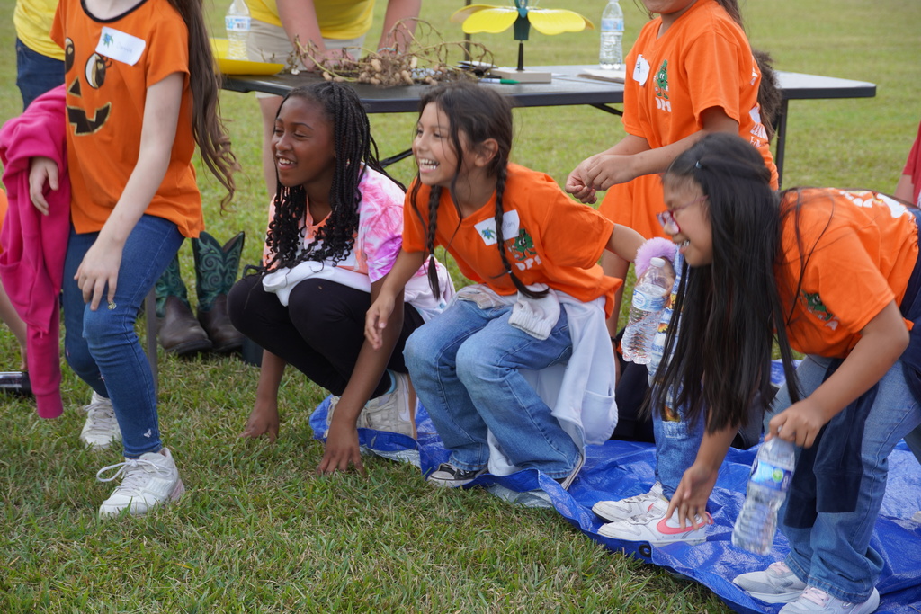 Students participate in hands-on agriculture activities during Ag ‘Em Up Day, learning about farm equipment, animals, and crop production.