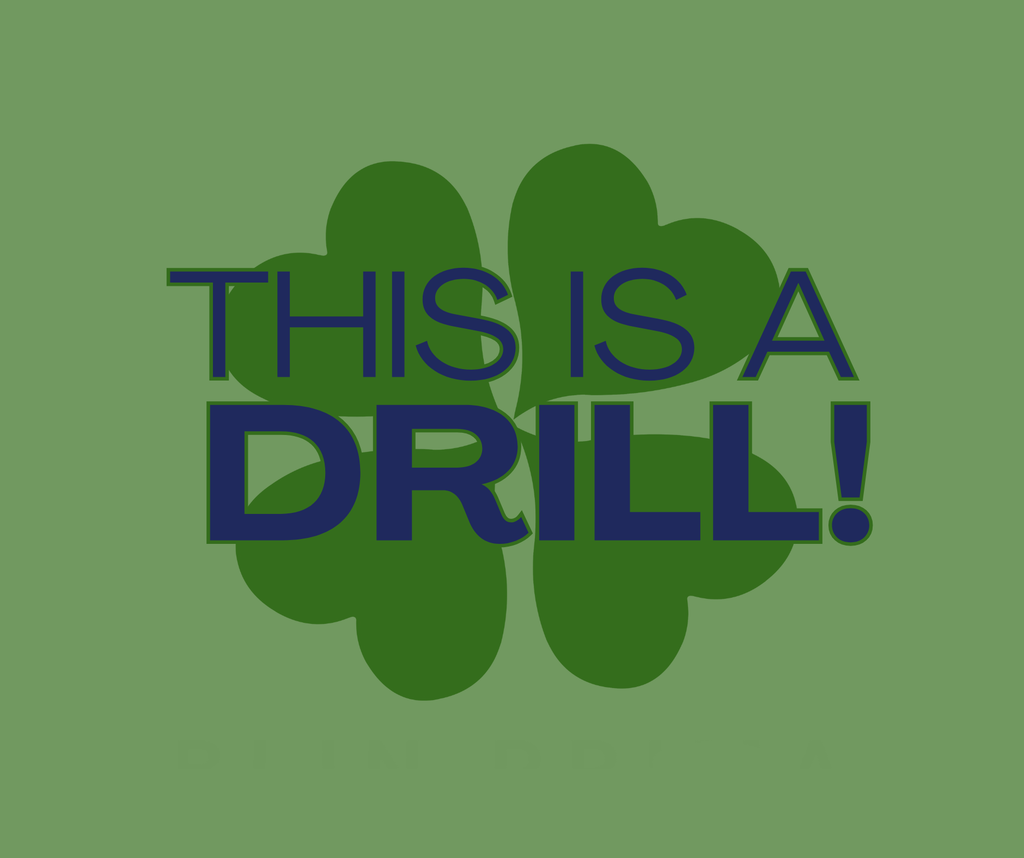 “Graphic with a large green four-leaf clover in the background and bold navy text in front that reads ‘THIS IS A DRILL!’ The background is solid green.”