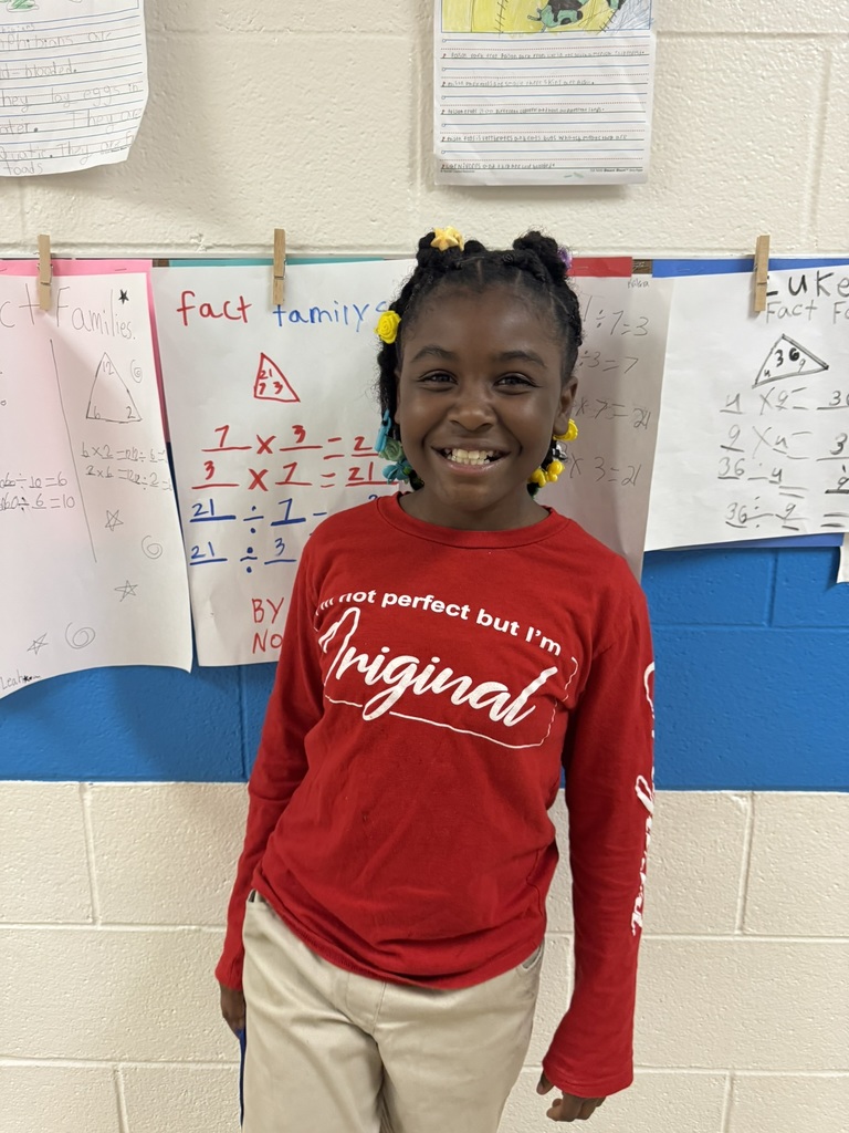 A young student smiling and wearing red clothing to celebrate Red Ribbon Week.