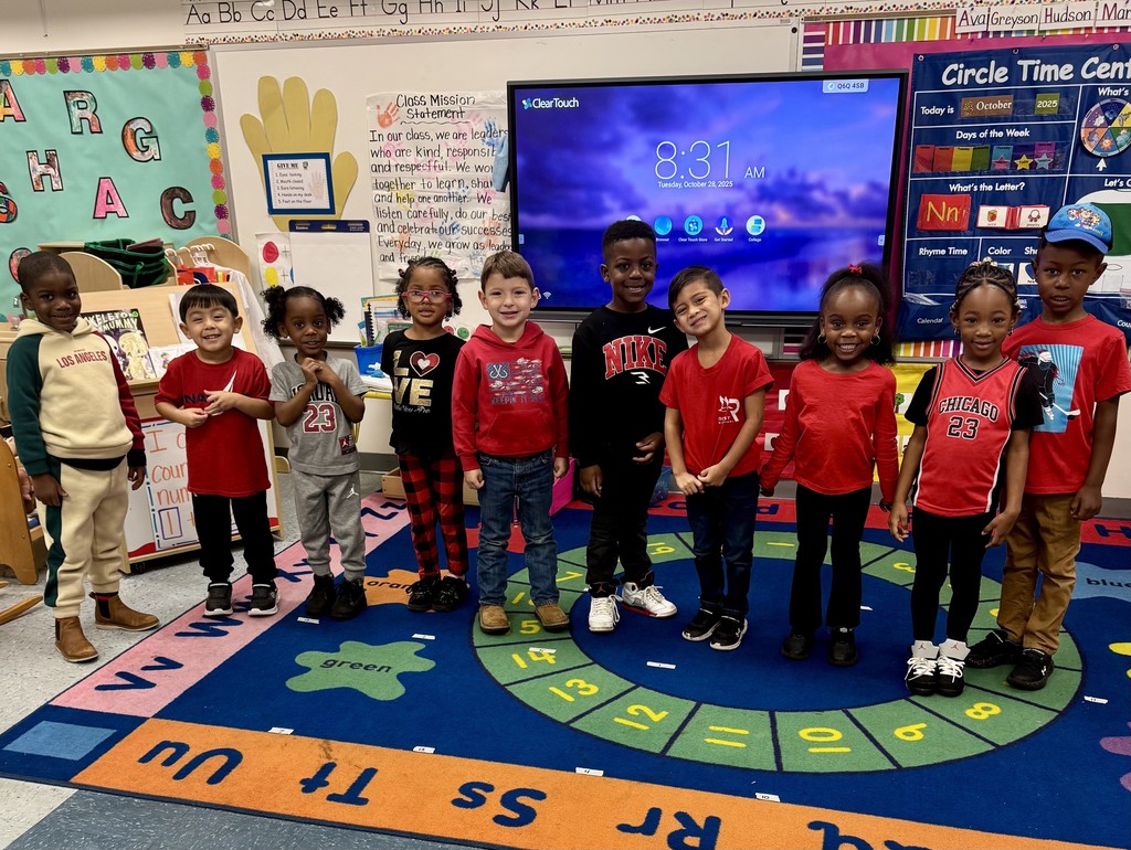 Two classroom groups of elementary students wearing red clothing for Red Ribbon Week. In the first image, a group of young children stands on a colorful classroom rug smiling in front of a smartboard