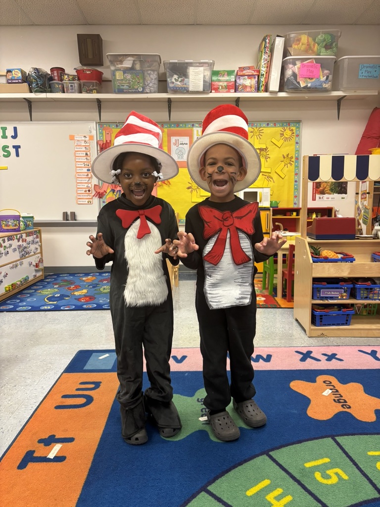 Two children dressed as Cat in the Hat with tall red-and-white striped hats, furry bellies, and red bow ties, smiling excitedly.