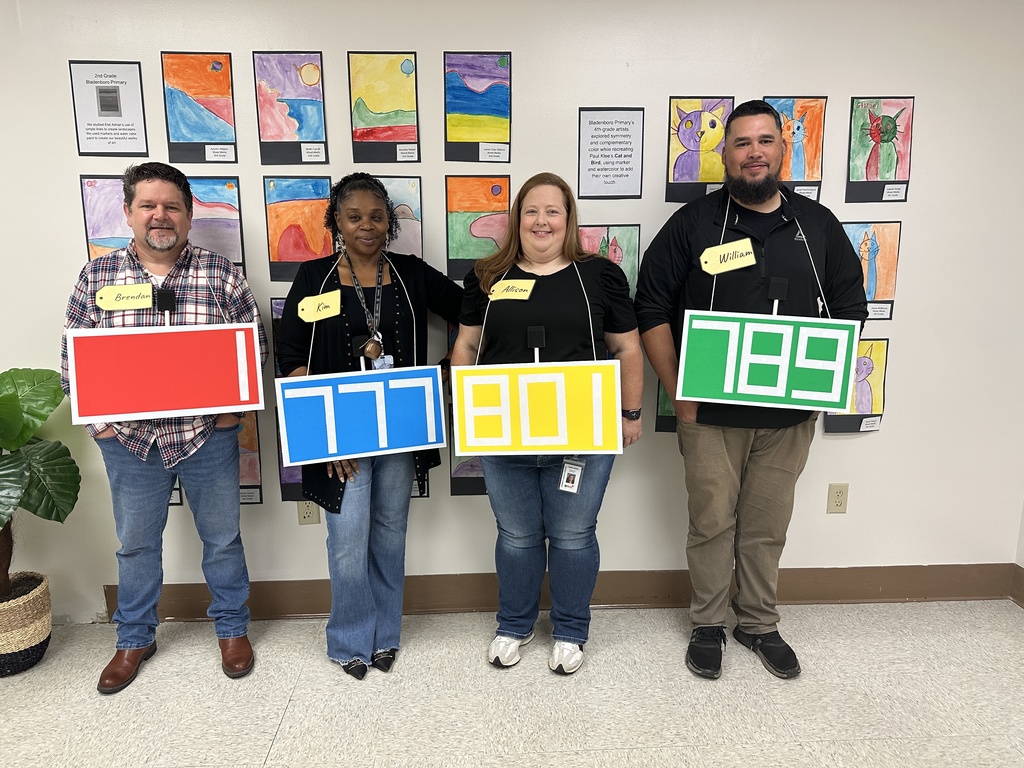 Four staff members pose together dressed as price tags from The Price Is Right.