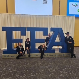 FFA students at Convention sitting on FFA monument