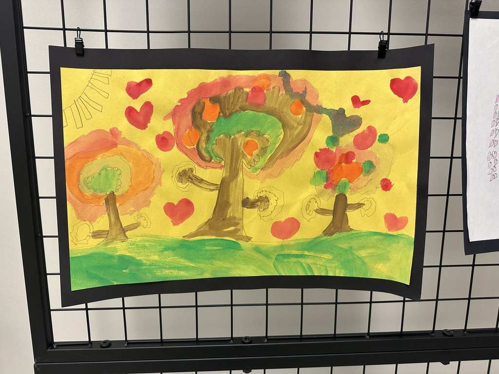 A bright scene of three painted trees with multicolored circular foliage and red hearts scattered across a yellow sky.