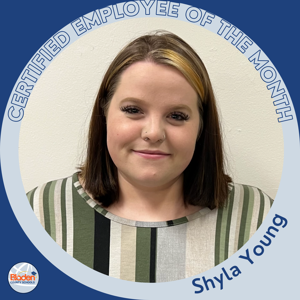 A woman with shoulder-length hair featuring a streak of blond stands against a plain light-colored wall. She wears a striped top and looks directly at the camera. A circular blue-and-gray frame reads “Certified Employee of the Month,” with “Shyla Young” at the bottom and the Bladen County Schools logo in the corner.