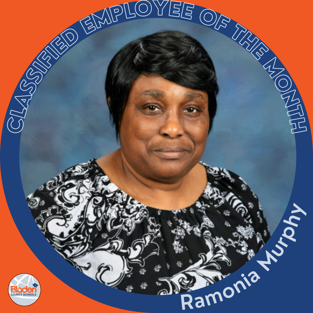 Portrait of a woman smiling slightly, shown inside a circular graphic that reads ‘Classified Employee of the Month.’ The name ‘Ramonia Murphy’ appears along the bottom. She is wearing a black and white patterned blouse against a blue studio-style background. A small Bladen County Schools logo is in the lower left corner.