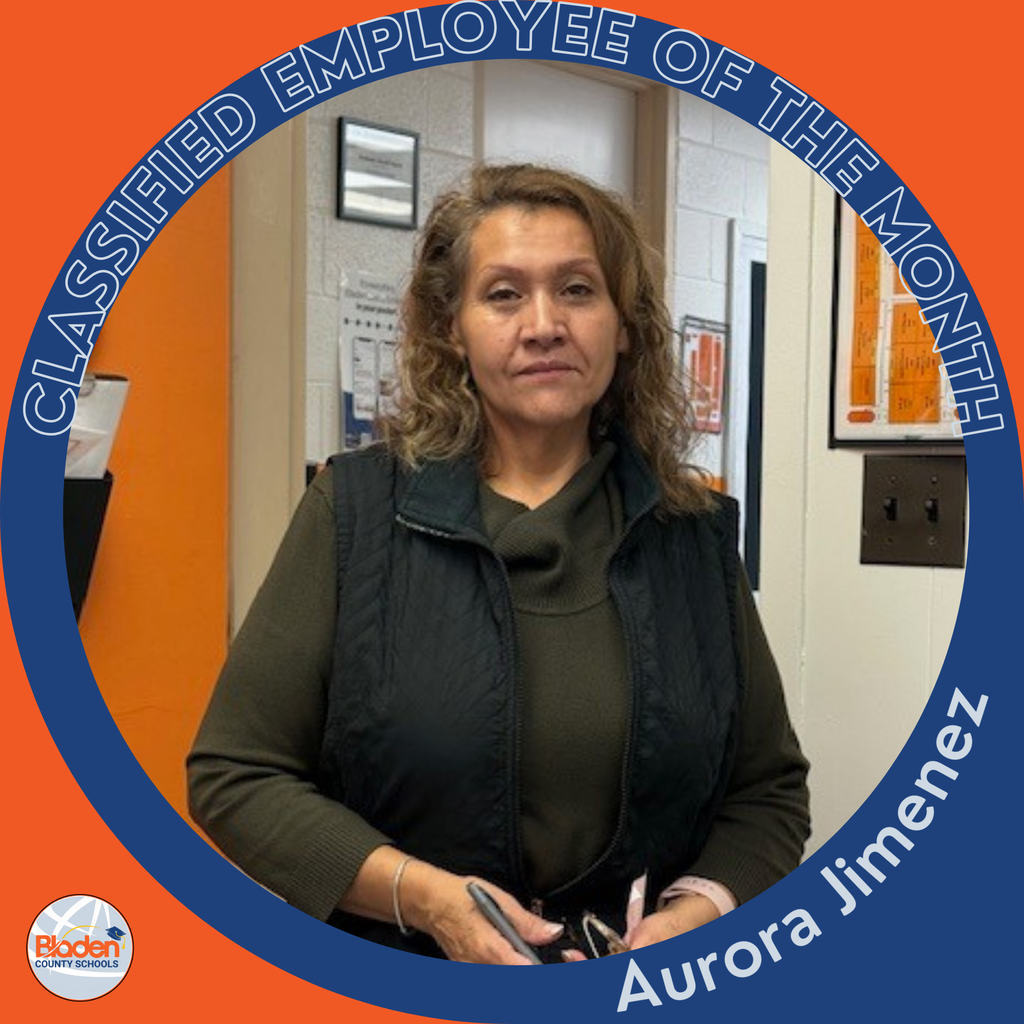 Circular graphic featuring a woman standing indoors, wearing a dark vest over a green long-sleeve top and holding a pair of glasses. The border reads “Classified Employee of the Month,” and the name “Aurora Jimenez” appears along the bottom. A Bladen County Schools logo is in the lower-left corner.