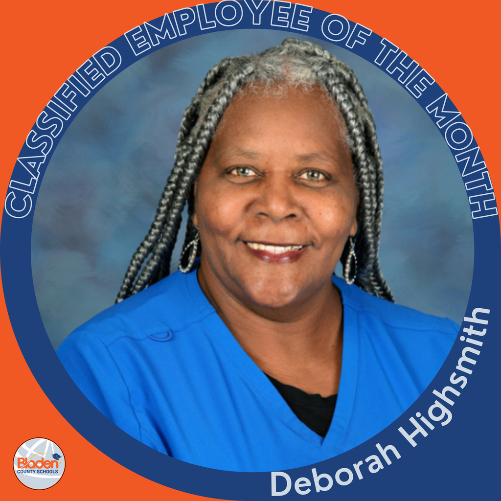 Circular ‘Classified Employee of the Month’ graphic featuring a woman smiling in a blue scrub top with long gray braids, posed in front of a blue background. Text on the graphic reads ‘Deborah Highsmith.