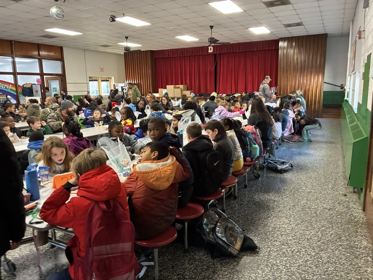 elementary school cafeteria filled with students and adults eating breakfast 