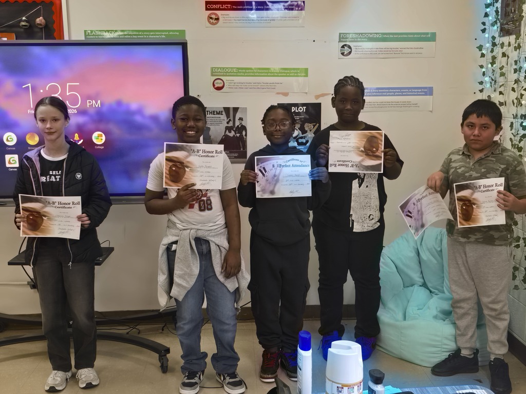 Six Elizabethtown Middle School students stand in front of a classroom display holding Honor Roll and Perfect Attendance certificates.