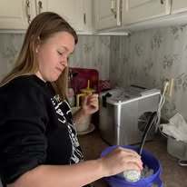 A student at home carefully pours ingredients into a bowl while participating in a hands-on snow cream making project