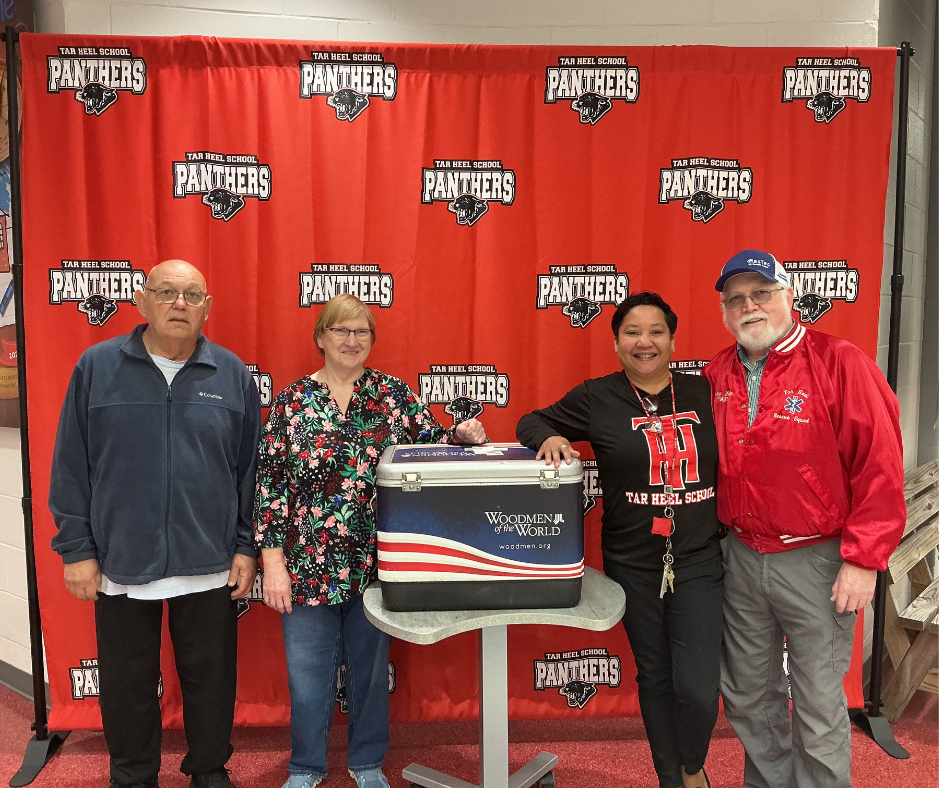 4 people in frame with a cooler. 