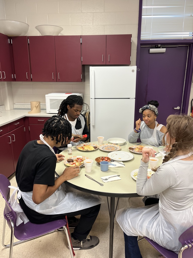 4 students seated around a table enjoying pancakes