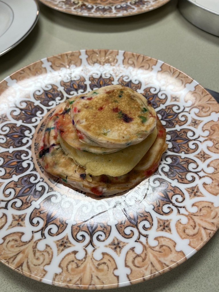 a stack of pancakes with colorful sprinkles in the batter