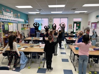 4 FFA students leading a class of elementary students in tree pose