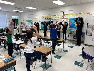 elementary students doing yoga directed by FFA students