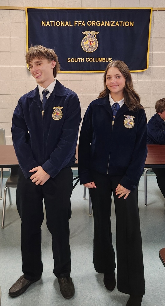 Two West Bladen FFA students stand professionally in official dress for a public speaking competition.
