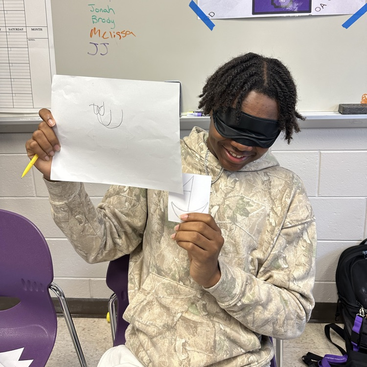 a student poses with his drawing