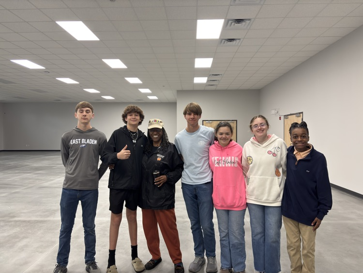 Six students standing with an adult at the new community center in Elizabethtown. the building looks newly constructed!