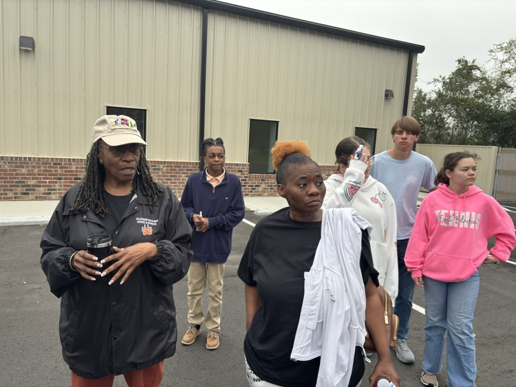 students standing outside of the community center with an adult