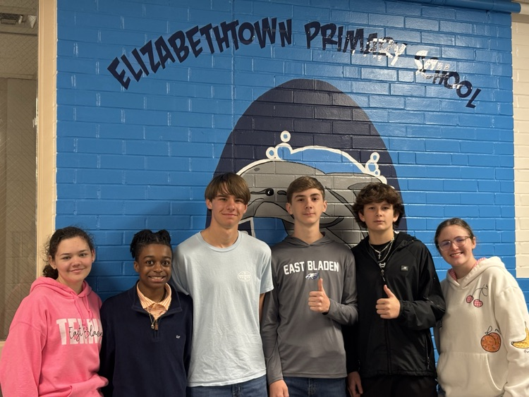 6 EBHS students staying in front of a blue brick wall that reads Elizabethtown primary