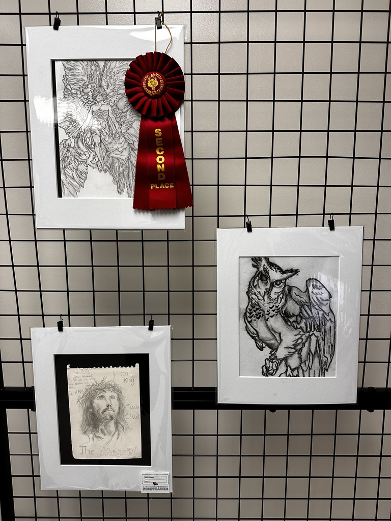 Display panel featuring detailed pencil drawings including an angel with wings (second place ribbon), an owl, and a portrait of Jesus labeled “The Messiah.”