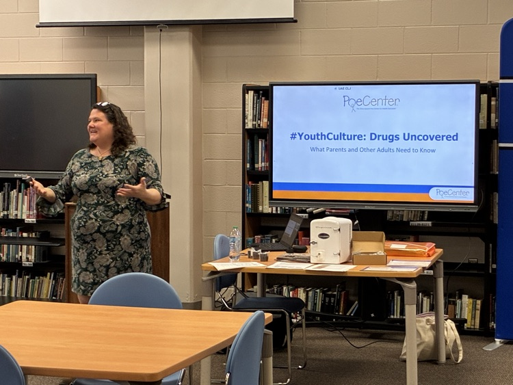 lady wearing a dress in a library presenting about youth culture