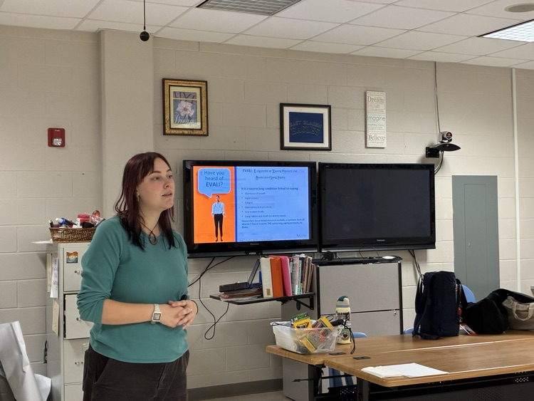 lady in a green shirt in front of a Cleartouch screen showing information on vaping