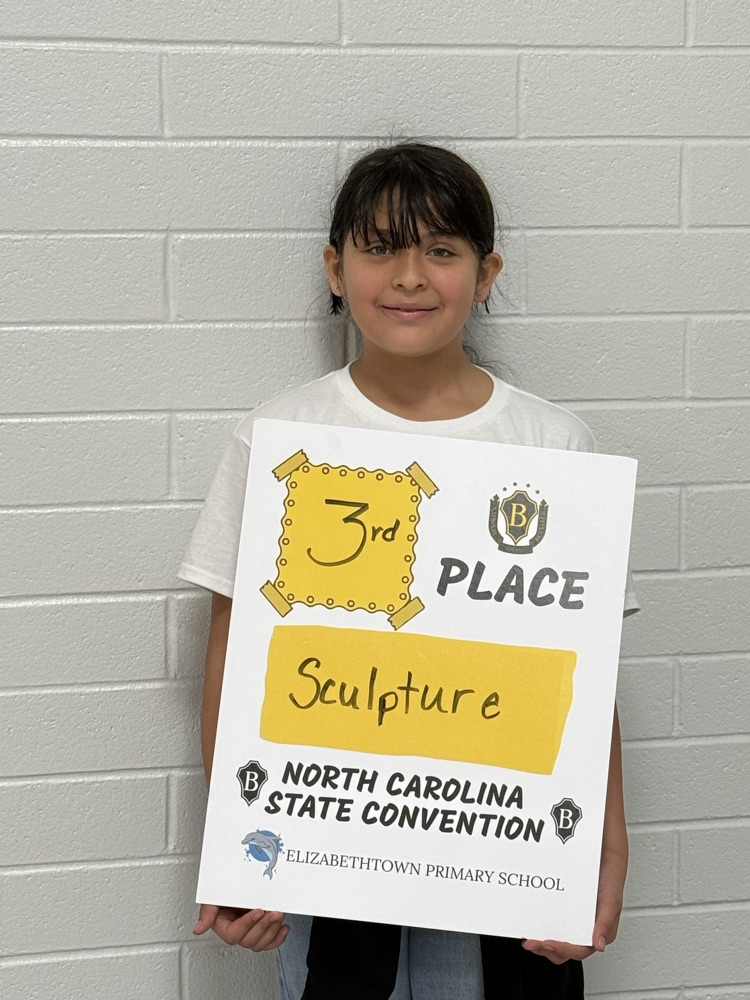 Student holding a sign celebrating 3rd place in sculpture at the North Carolina State Beta Convention for Elizabethtown Primary School.