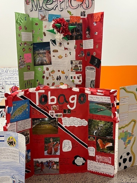 Colorful student cultural project boards about Mexico and Tobago decorated with photos, maps, and information about traditions, food, and landmarks.