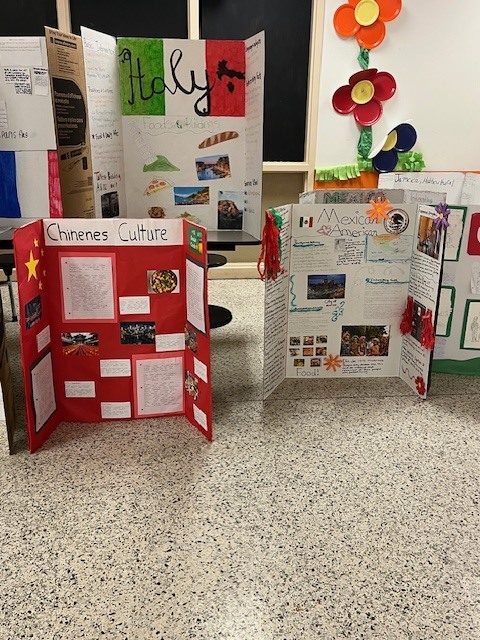 Student cultural displays about Italy, Chinese culture, and Mexican American culture arranged around the classroom with photos and written research.