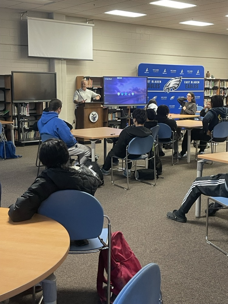 students in a library while a man presents to them about financial literacy
