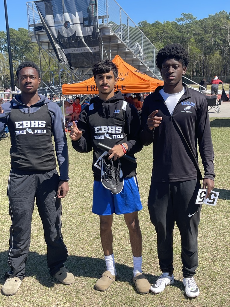 Three male students posing with the track uniforms and gear.