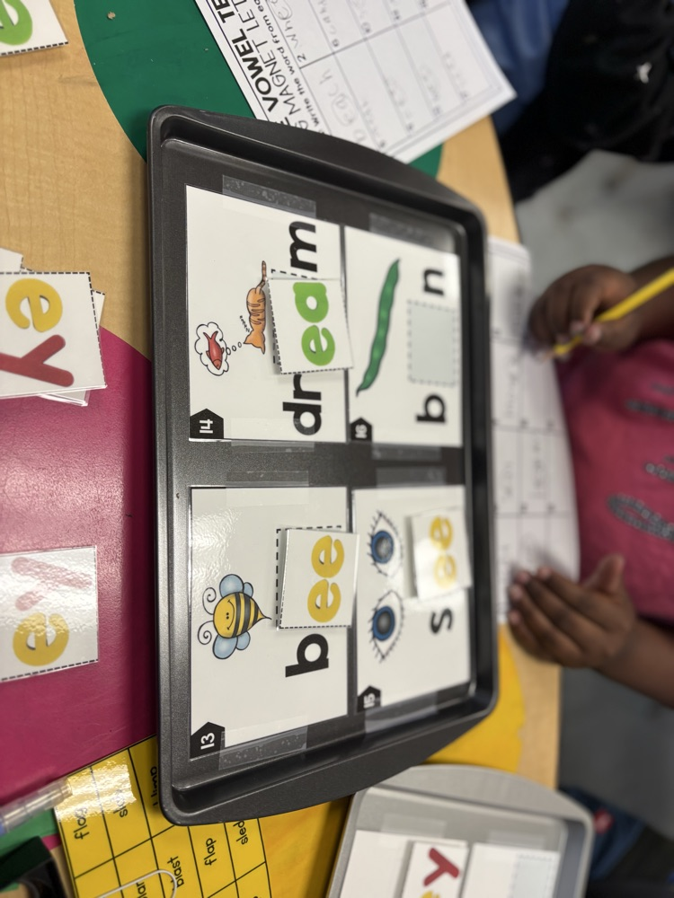 First grade students use magnetic letter tiles to build long vowel E words with vowel teams like ee and ea during a hands-on literacy activity.