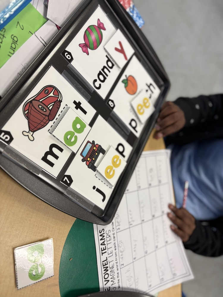 First grade students use magnetic letter tiles to build long vowel E words with vowel teams like ee and ea during a hands-on literacy activity.