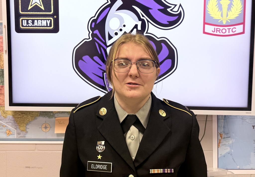 Madison Eldridge, West Bladen High School JROTC Cadet of the Quarter, wearing her military uniform and smiling while holding an award certificate.