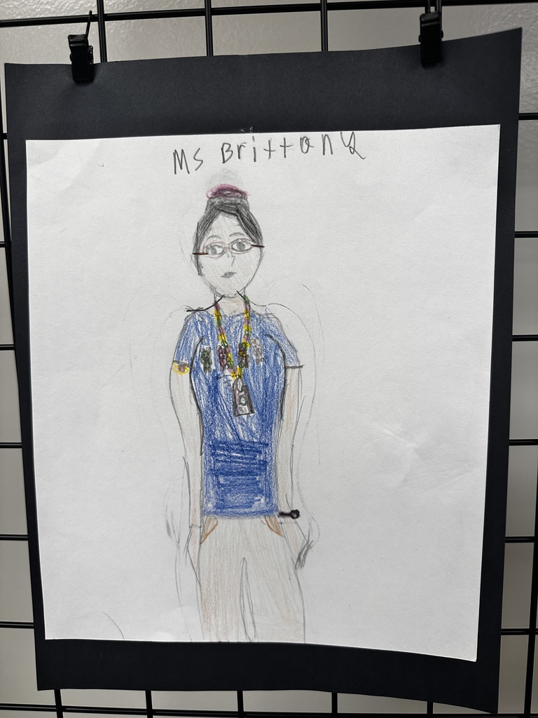 Child's colored pencil portrait of a teacher labeled "Ms Brittona" wearing glasses and a blue shirt