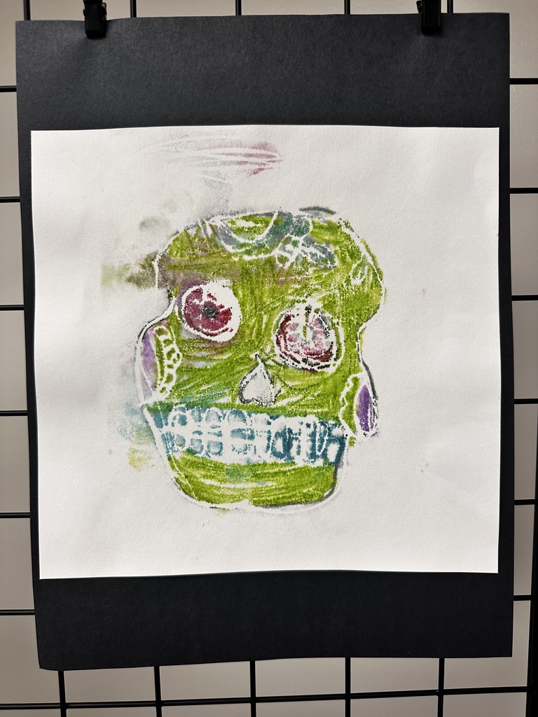 Child's mixed media collage of a face using cut paper shapes on a colorful crayon-textured background