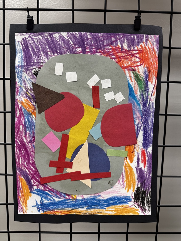 Child's printmaking artwork of a colorful sugar skull in green, purple, and red